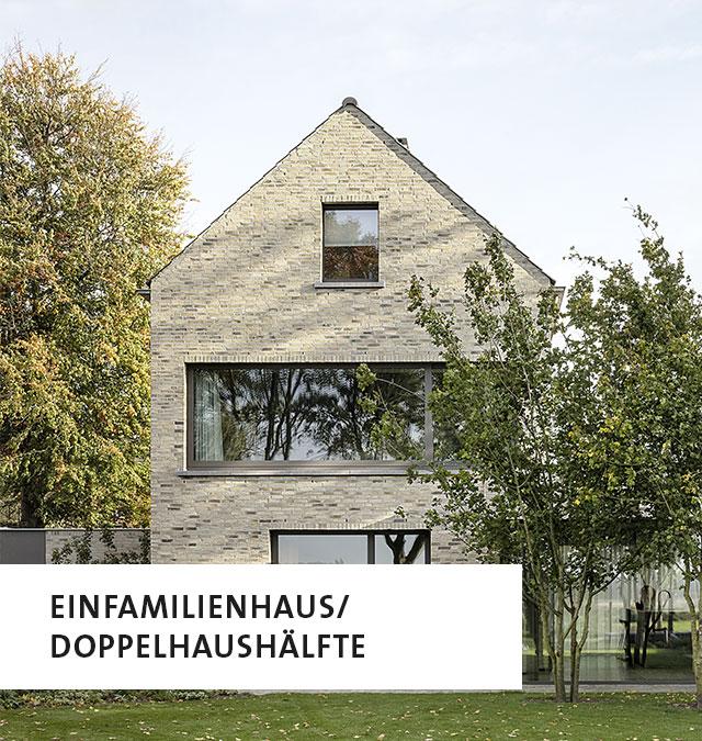 Ein Einfamilienhaus mit hellbeigem Backstein, links unten die Aufschrift: Einfamilienhaus/Doppelhaushälfte